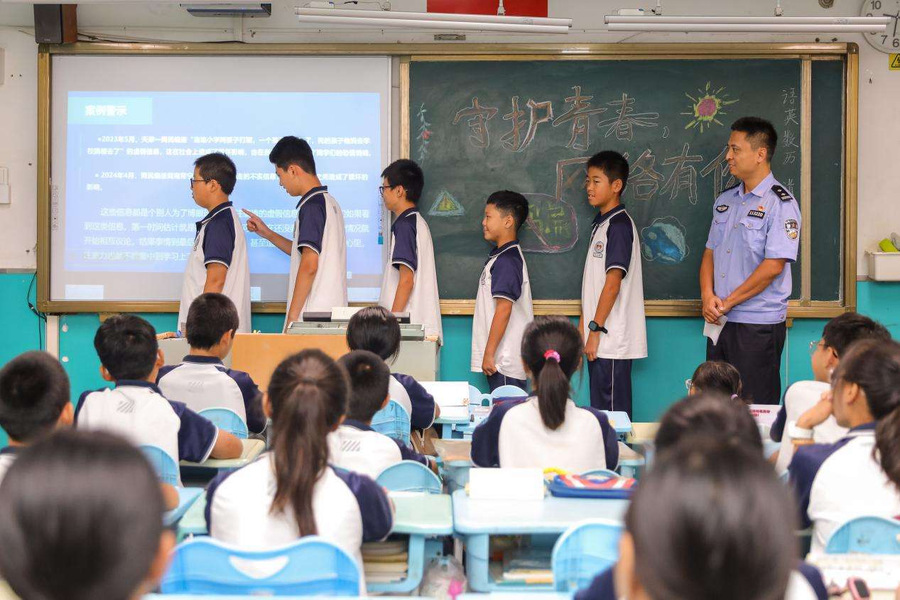 2024年9月9日，在山东省青岛市第三十一中学，学生在民警的带领下进行“寄语”互动游戏。张鹰